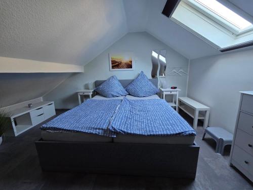 a bedroom with a large blue bed with blue pillows at Zur Königslay in Bullay
