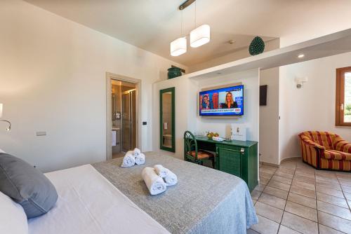 a bedroom with a bed with towels on it at Hotel Baia Del Capitano in Cefalù