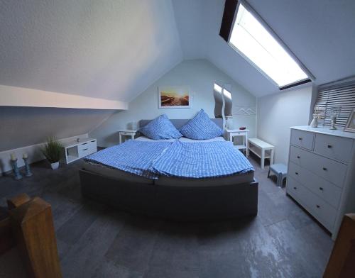 a bedroom with a bed with a blue comforter and a window at Zur Königslay in Bullay