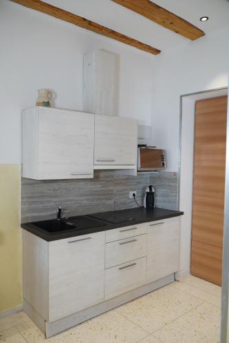 a kitchen with white cabinets and a black counter top at Gardar in Bolzano