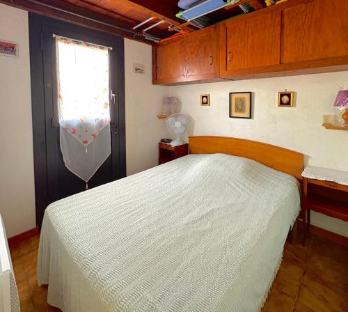 une chambre avec un lit blanc et une fenêtre dans l'établissement Maison 4 personnes terrasse accès direct à la plage 4JM6, au Barcarès