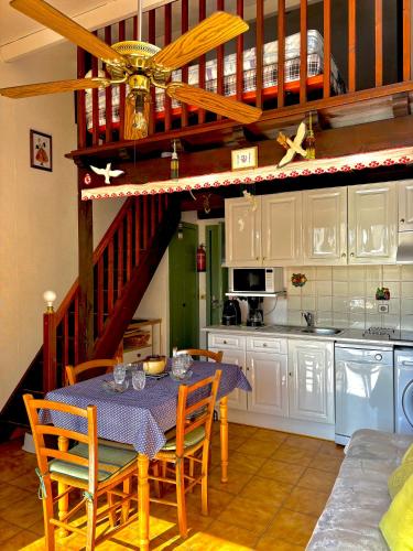 une cuisine avec une table et des chaises ainsi qu'un escalier dans l'établissement Maison 4 personnes terrasse accès direct à la plage 4JM6, au Barcarès