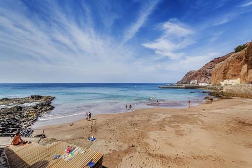 a group of people on a beach near the ocean at Brisas de Sardina Apartment in Sardina