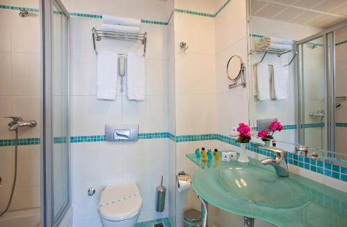 Örsmaris Boutique Hotel في مرماريس: حمام مع حوض أخضر ودش