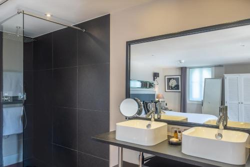 a bathroom with two sinks and a large mirror at La Villa Mauresque in Saint-Raphaël