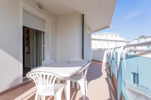 a white table and chairs on a balcony at Residence Marconi Mare in Rimini