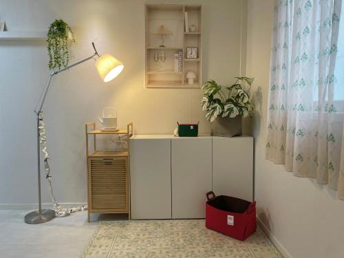 a room with a lamp and a desk with a plant at Moeul Stay in Gyodong in Daegu