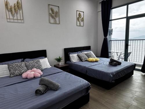 two beds with pillows on them in a bedroom at 9人2房海景套房 Seaview 2bedroom 9 pax bay suite near kk town by Gc in Kota Kinabalu