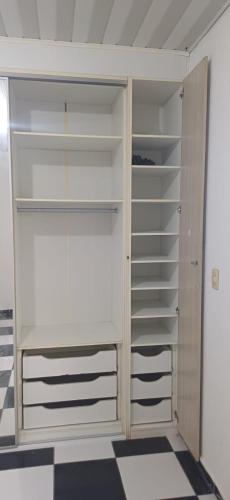 a closet with white shelves in a room at Casa para a COP 30 in Barcarena