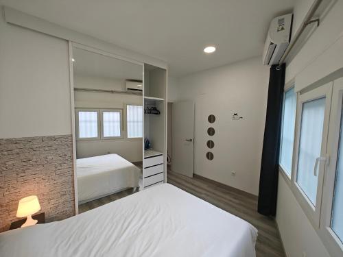 a bedroom with two beds and a mirror at Zona muy tranquila todo nuevo in Madrid