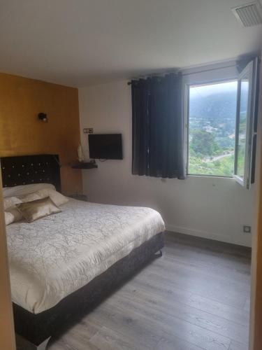 une chambre avec un grand lit et une fenêtre dans l'établissement Magnifique appartement - St Martin de Peille, à Peille