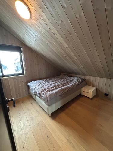 un lit dans une chambre avec un plafond en bois dans l'établissement Soleiknuten Ålsheia Moderne Hytte i Naturskjønne Omgivelser, à Tjørhom