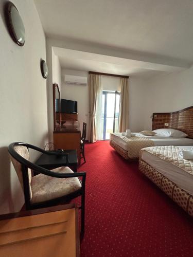 a hotel room with two beds and a red carpet at Hotel Bavaria Trogir in Trogir