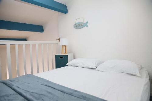 - une chambre avec un lit et une horloge de poisson sur le mur dans l'établissement Saint Cyprien jolie maison climatisee, à Saint-Cyprien