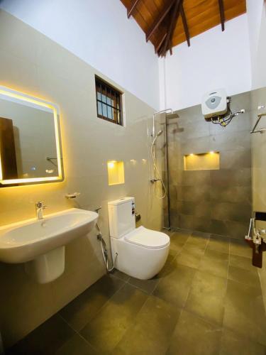 a bathroom with a toilet and a sink and a shower at Villa Navodi in Negombo