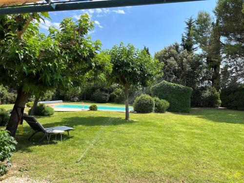 une cour avec une table, un banc et une piscine dans l'établissement Provencal Villa with Heated Pool near Lourmarin, à Lauris