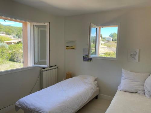 - une chambre blanche avec 2 lits et 2 fenêtres dans l'établissement Provencal Villa with Heated Pool near Lourmarin, à Lauris