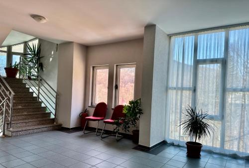 a room with two chairs and a staircase with windows at Wellness & Spa - Hotel Oaza in Jošanička Banja