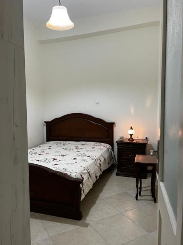 a bedroom with a bed and a table and a lamp at Kantouni house Chios in Pyrgi