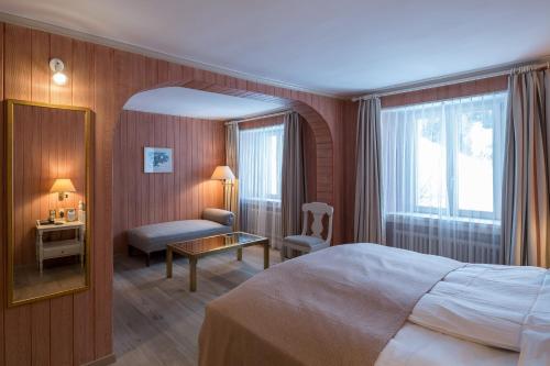 a hotel room with a large bed and a desk at Hotel Post in Bivio