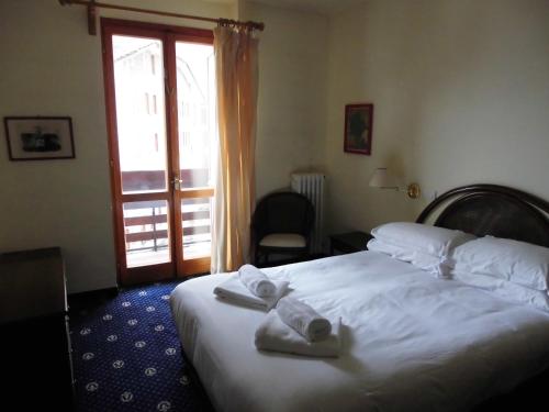 a hotel room with a bed with towels on it at Hotel Residence Valverde in Gressoney-la-Trinité