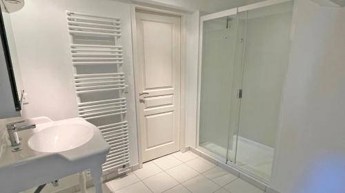 une salle de bain blanche avec une douche et un lavabo dans l'établissement Villa Les Amandiers, à Sainte-Maxime