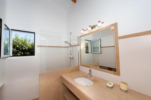 un baño con lavabo y espejo en Ficula Vell Beachfront Villa with Private Pool, en Punta Grossa