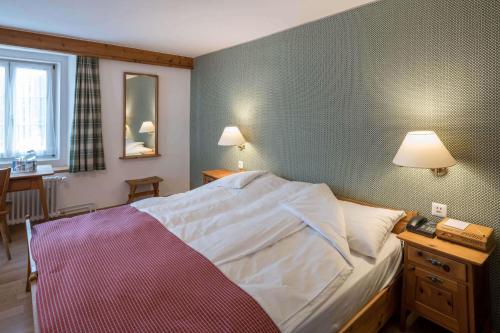 a bedroom with a bed and a green wall at Hotel Post in Bivio