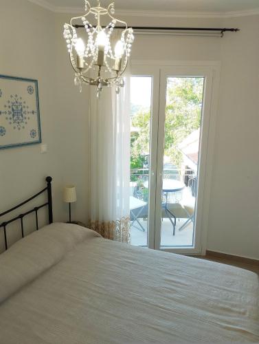a bedroom with a bed and a chandelier at EAR - house Karia Lefkada in Kariá