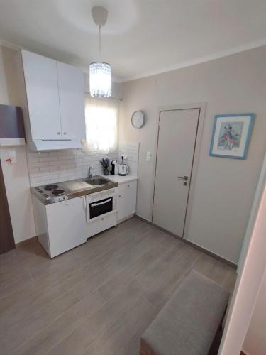 a white kitchen with a sink and a stove at EAR - house Karia Lefkada in Kariá