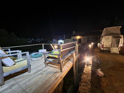 a deck with two benches and a rv at night at EMMY'S HIDE AWAY in Iringa
