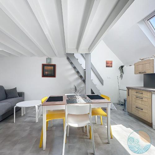 une cuisine et une salle à manger avec une table et des chaises dans l'établissement Le Nid Marin, à Quiberon