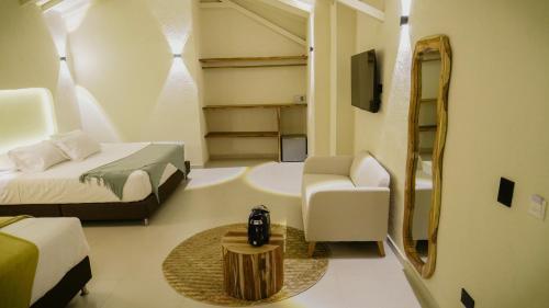 a room with two beds and a chair and a mirror at Talam House Coveñas by Bernalo Hotels in Coveñas