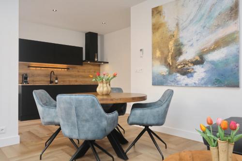 a dining room with a table and four chairs at Steenhof Beach House in Noordwijk