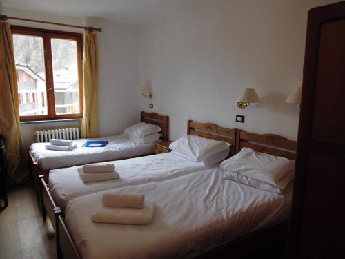 two twin beds in a room with a window at Hotel Residence Valverde in Gressoney-la-Trinité