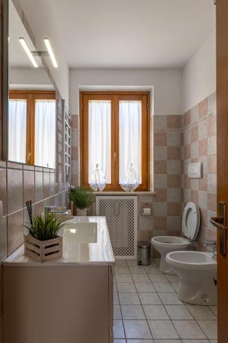 a bathroom with two sinks and a toilet and a mirror at Il Cammino in San Quirico dʼOrcia