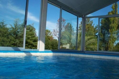a large swimming pool with a large group of windows at Hotel La Posta del Dayman in Termas del Daymán