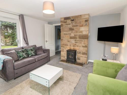 a living room with a couch and a fireplace at Cheshire House in Castleton