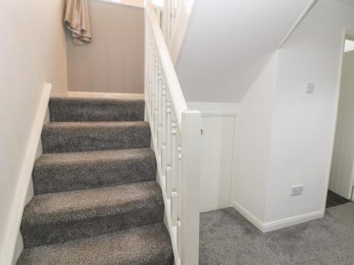 a staircase in a home with gray carpet at Cheshire House in Castleton