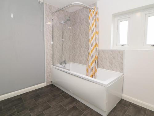 a white bathroom with a tub and a shower at Cheshire House in Castleton