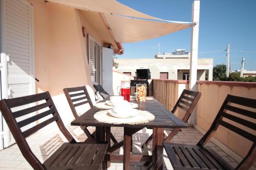 a wooden table and chairs on a balcony at VILLA CALA BERNARDO 2 Appartamenti in Calabernardo