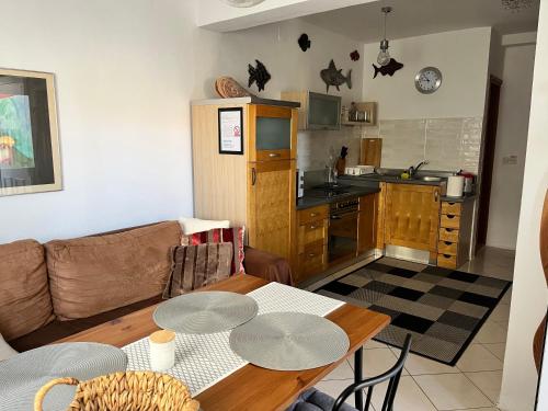 Una sala de estar con una mesa y una cocina. en Anna's holiday home, en Supetar