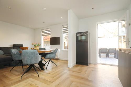 a kitchen and living room with a table and chairs at Steenhof Beach House in Noordwijk