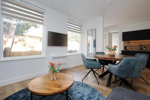 a living room with a table and chairs at Steenhof Beach House in Noordwijk