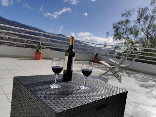 eine Flasche Wein und zwei Gläser auf einem Tisch in der Unterkunft Pico Barcelos - Funchal in Funchal