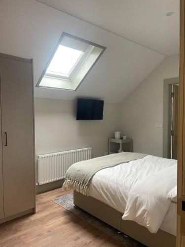 a bedroom with a large bed with a skylight at Gills Courtyard Accommodation in Crossmolina
