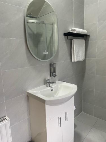 a bathroom with a white sink and a mirror at Gills Courtyard Accommodation in Crossmolina