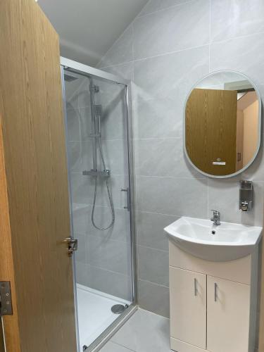 a bathroom with a shower and a sink and a mirror at Gills Courtyard Accommodation in Crossmolina