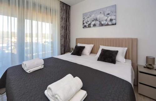 a bedroom with a large bed with towels on it at Sunny Oasis in Bibinje