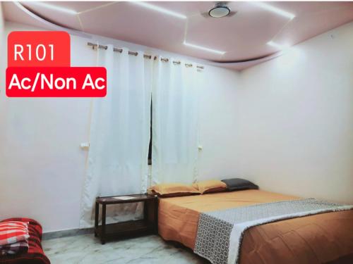 a bedroom with a bed and a sign that reads ra ac non ac at Shriguru Guest House Akkalkot in Akalkot